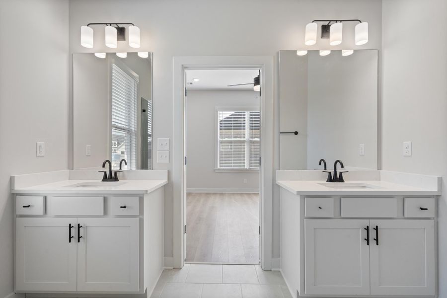 Dual vanity with white cabinetry, matte black fixtures, and framed mirrors Dual vanity with white cabinetry, matte black fixtures, and framed mirrors