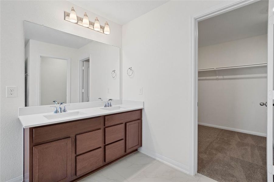 This primary bathroom is definitely move-in ready! Featuring stained cabinets with light countertops, dual vanities, walk-in closet, high ceilings, neutral paint, sleek and modern finishes.