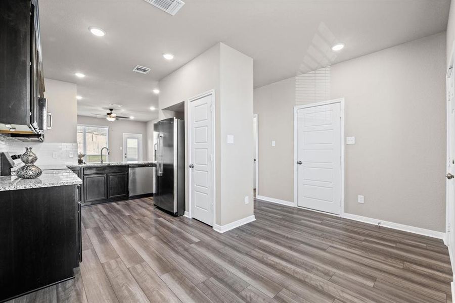 Kitchen with light stone countertops, stainless steel appliances, recessed lighting, ceiling fan, and light wood-style floors Kitchen with light stone countertops, stainless steel appliances, recessed lighting, ceiling fan, and light wood-style floors