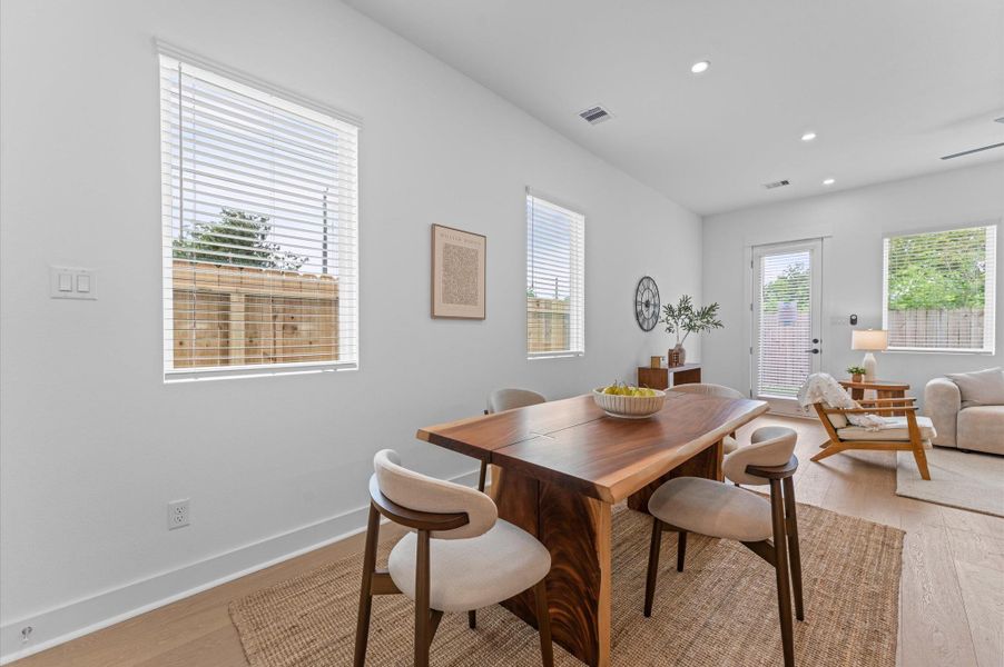 Elegant and inviting dining area designed for both everyday meals and special gatherings. The space features a well-proportioned layout that comfortably accommodates a full-size dining table, surrounded by stylish seating. Natural light filters in through nearby windows or glass doors, highlighting the room’s neutral palette and contemporary finishes.