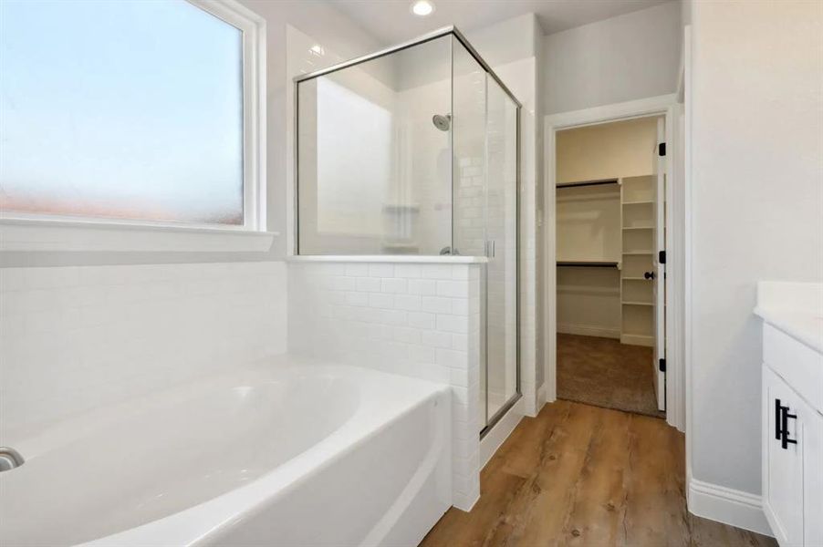 Bathroom with vanity, separate shower and tub, and hardwood / wood-style floors