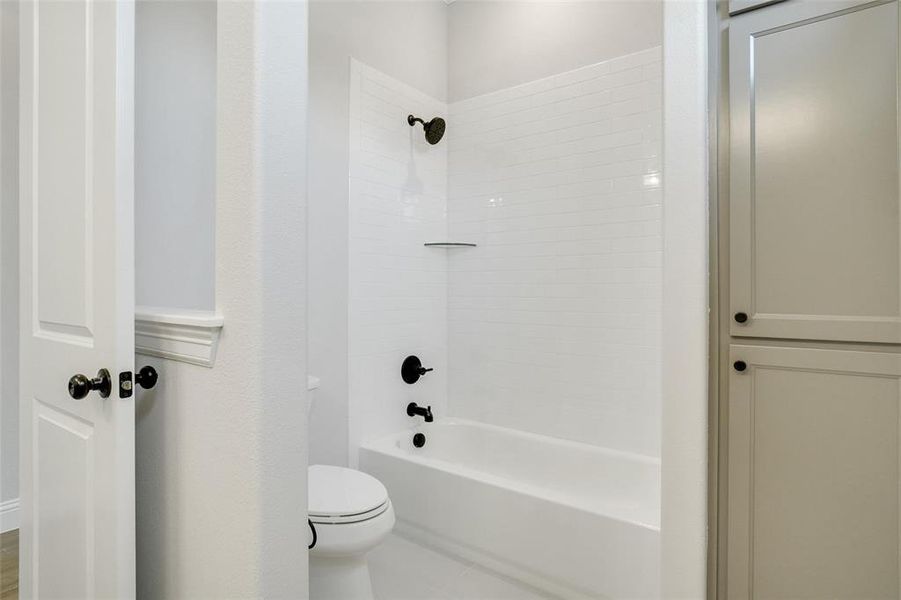 Bathroom with toilet and tiled shower / bath