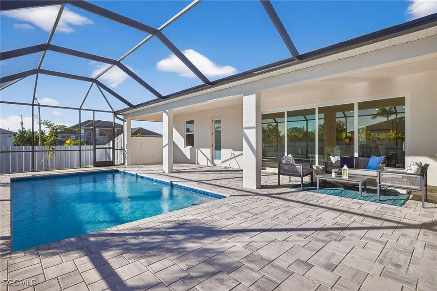 View of swimming pool with a sunroom, a patio, and glass enclosure
