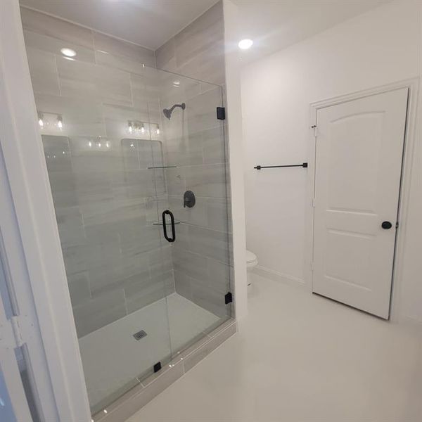 Bathroom with a shower with shower door and toilet