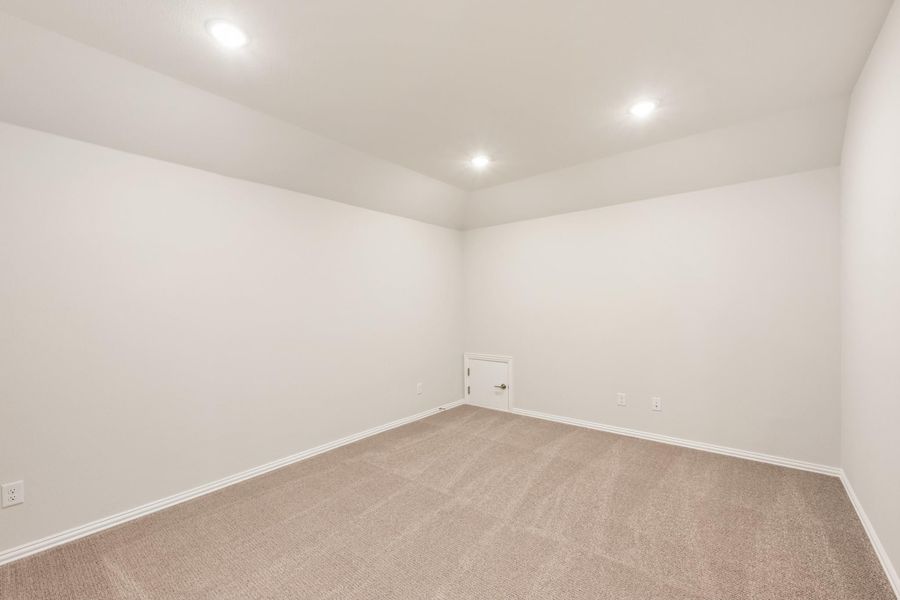 Empty room with beige carpet, white walls, recessed lighting, and a small door Empty room with beige carpet, white walls, recessed lighting, and a small door