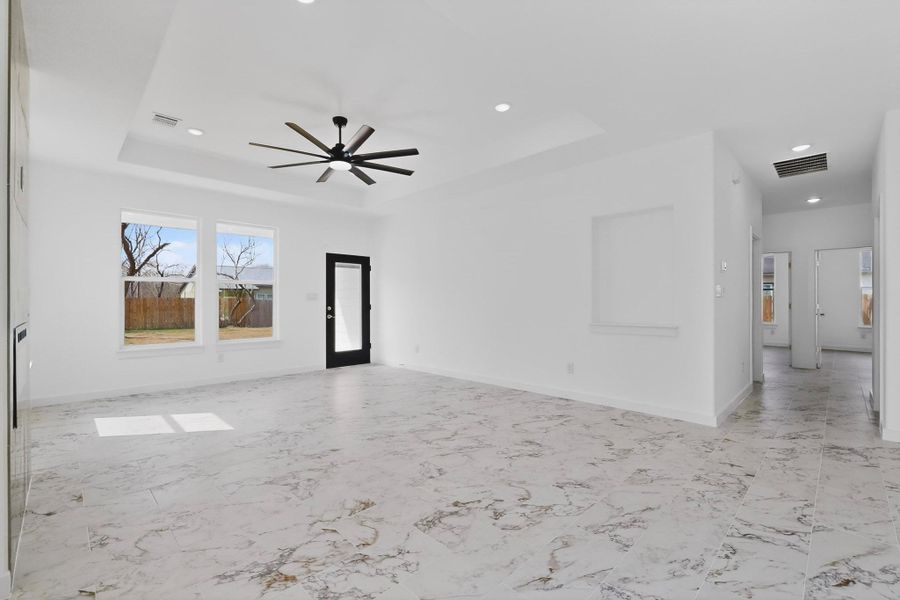 Living Room featuring a ceiling fan, recessed lighting, a tray ceiling, and a electric fireplace