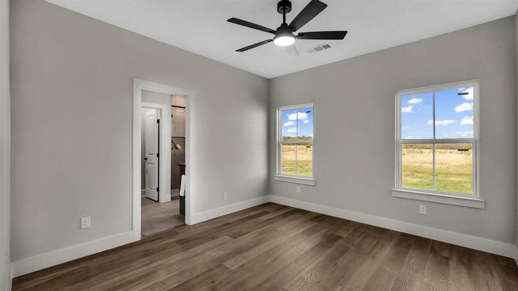 Unfurnished bedroom with dark wood-type flooring and ceiling fan