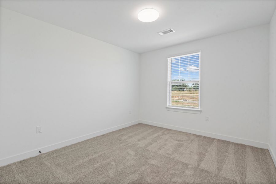 Neutral wall finishes, light-toned carpeting, and a window with blinds Neutral wall finishes, light-toned carpeting, and a window with blinds