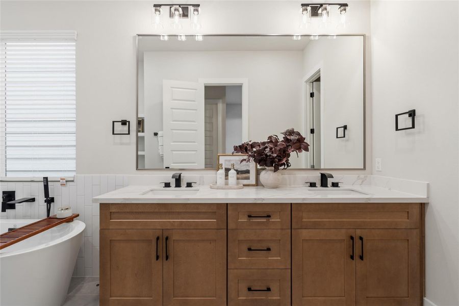 Clean lines and thoughtful design define the space, with a frameless walk-in shower and a wide dual-sink vanity offering ample counter space. Soft-close cabinetry enhances everyday ease. Clean lines and thoughtful design define the space, with a frameless walk-in shower and a wide dual-sink vanity offering ample counter space. Soft-close cabinetry enhances everyday ease.