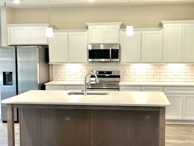 Wonderful textured backsplash highlighted by undercabinet lighting.