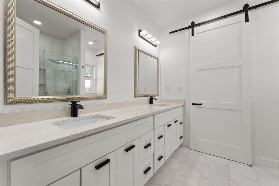 Full bath with double vanity, a stall shower, and light marble finish floors