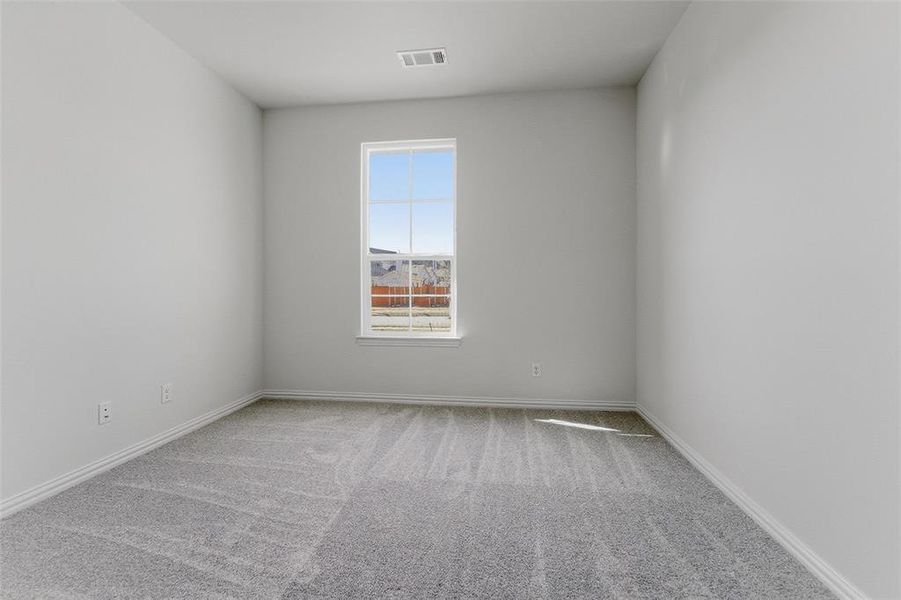 Empty room featuring light colored carpet and baseboards