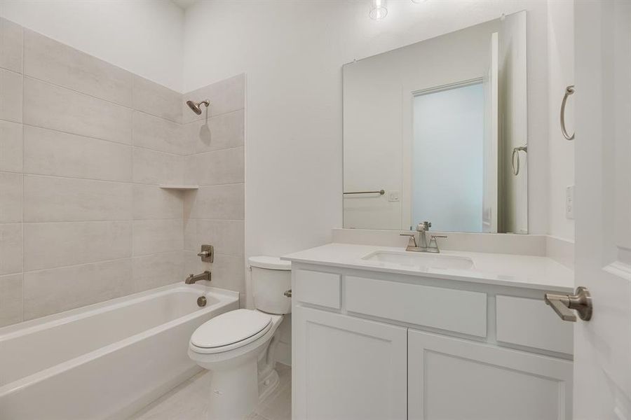 Bathroom featuring  shower combination, vanity, and light tile patterned floors