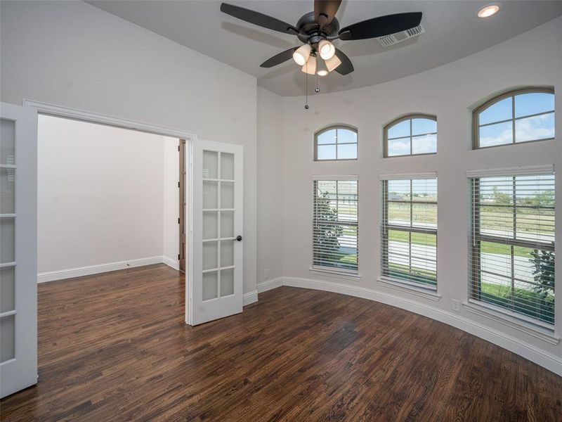 Empty room with dark wood-type flooring, ceiling fan, and recessed lighting Empty room with dark wood-type flooring, ceiling fan, and recessed lighting