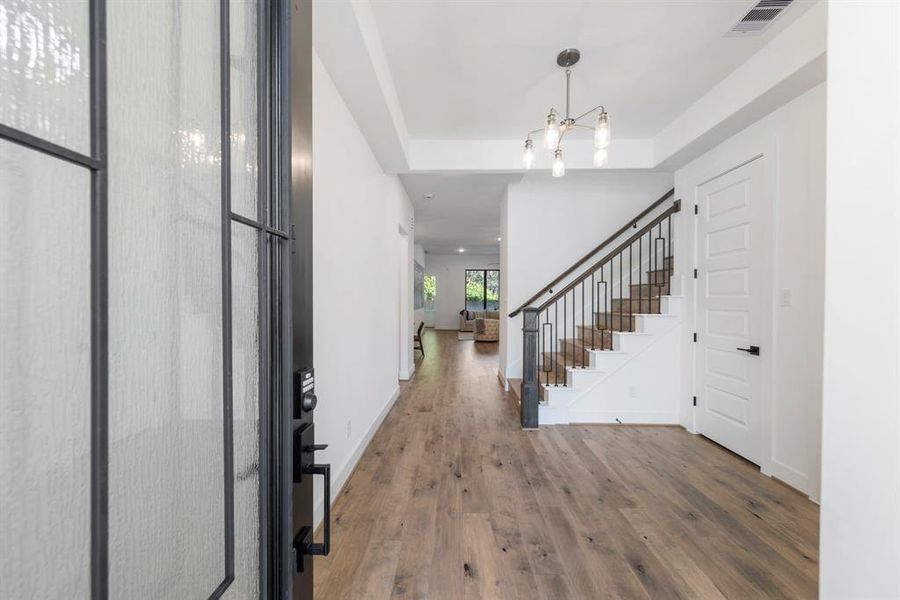 As you step inside, you’re greeted by soaring ceilings, a beautifully crafted tray ceiling in the entryway, rich engineered wood flooring throughout, and a tasteful neutral color palette.