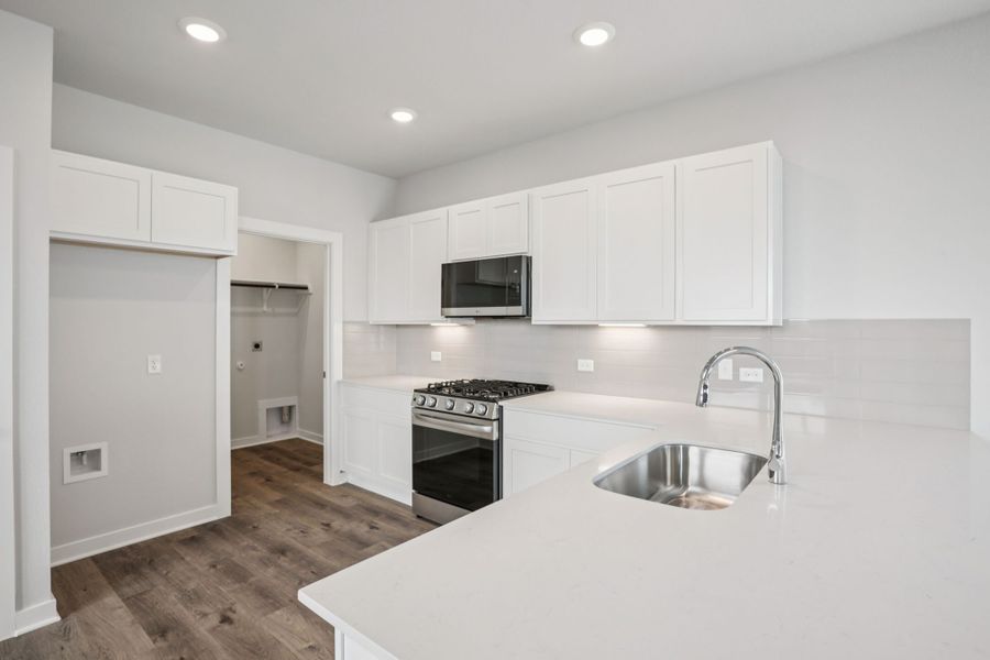 A kitchen with white cabinets.