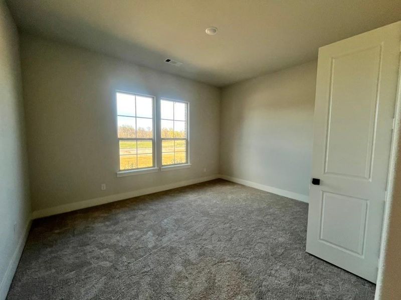 Carpeted empty room featuring baseboards