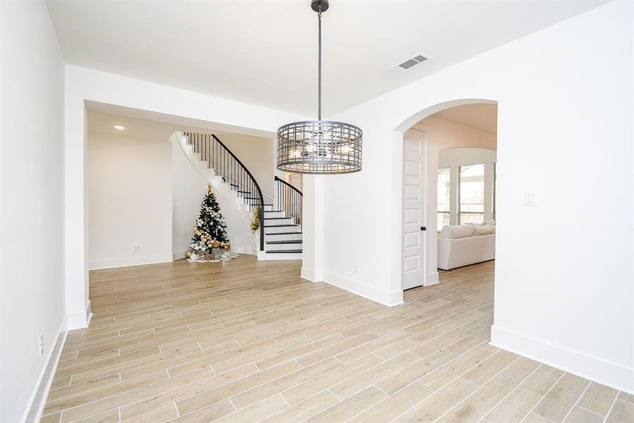 The layout promotes easy flow between the kitchen and dining area, fostering a sense of togetherness. meals and entertaining guests. The room is accentuated by a modern light fixture that serves as a striking focal point, illuminating the space with a warm glow.