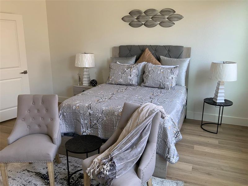 Bedroom featuring light wood finished floors and baseboards Bedroom featuring light wood finished floors and baseboards