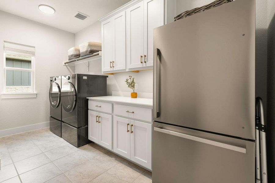 Well-equipped laundry room with cabinetry and workspace.