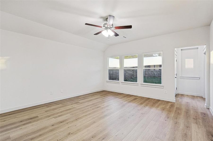 Spare room with ceiling fan, light hardwood / wood-style flooring, and vaulted ceiling