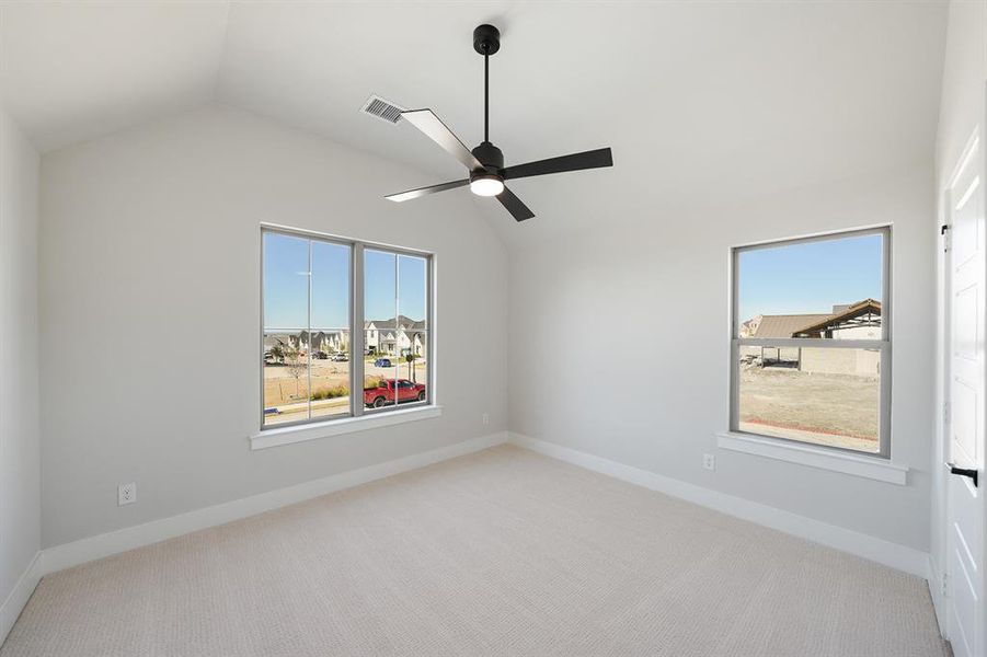 Spare room with lofted ceiling, light carpet, ceiling fan, and plenty of natural light Spare room with lofted ceiling, light carpet, ceiling fan, and plenty of natural light