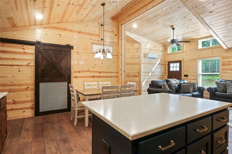 Kitchen featuring decorative light fixtures, dark wood-type flooring, wood ceiling, and wood walls