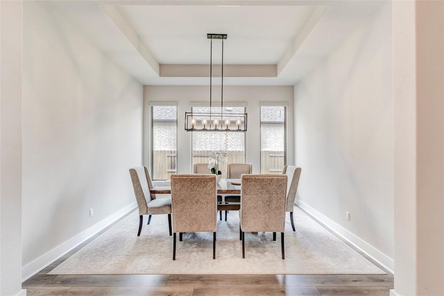 A well-lit dining area features a tray ceiling, showcasing the potential for elegant entertaining.