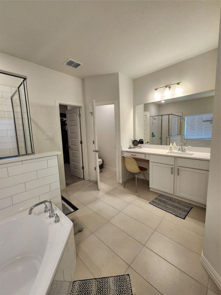 Indulge in a primary bathroom featuring both a soaking tub and a separate glass-enclosed shower.
