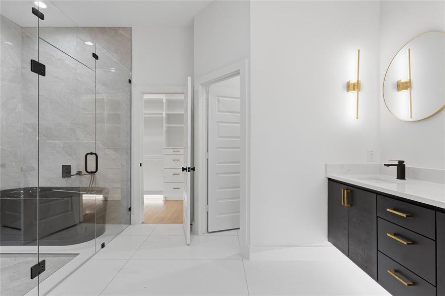 Bathroom with vanity, a marble finish shower, a walk in closet, and light tile patterned flooring Bathroom with vanity, a marble finish shower, a walk in closet, and light tile patterned flooring