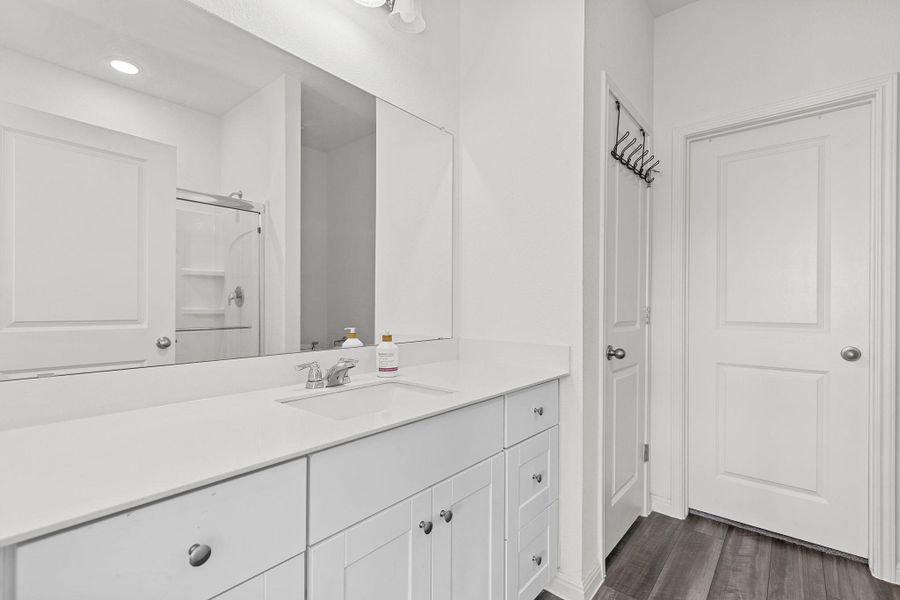 Full bathroom with vanity, dark wood-style flooring, and an enclosed shower Full bathroom with vanity, dark wood-style flooring, and an enclosed shower