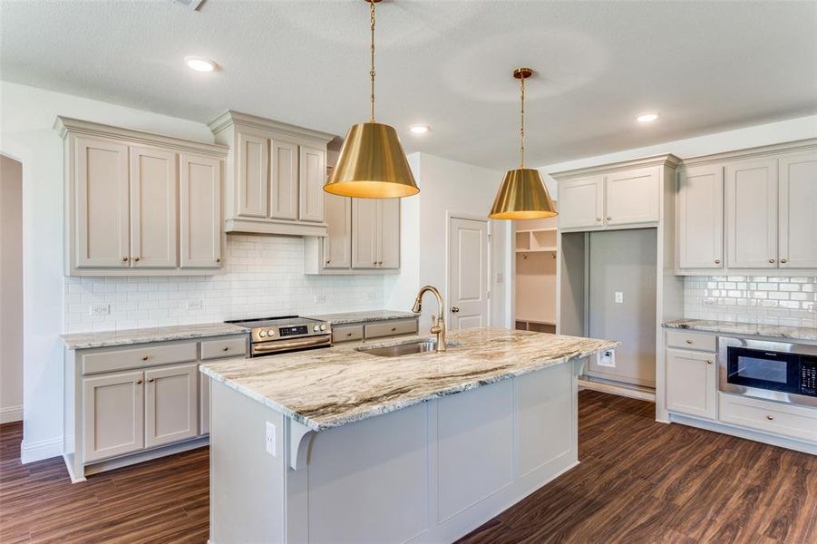 Kitchen featuring stainless steel appliances, backsplash, decorative light fixtures, dark hardwood / wood-style floors, and sink