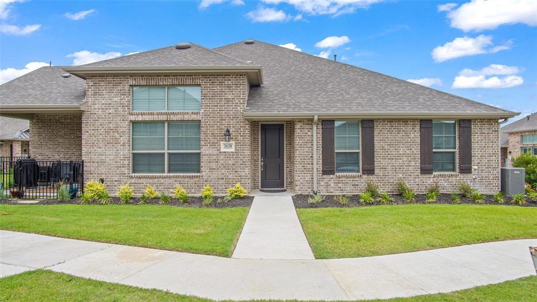 View of front of home with a front yard and central AC unit