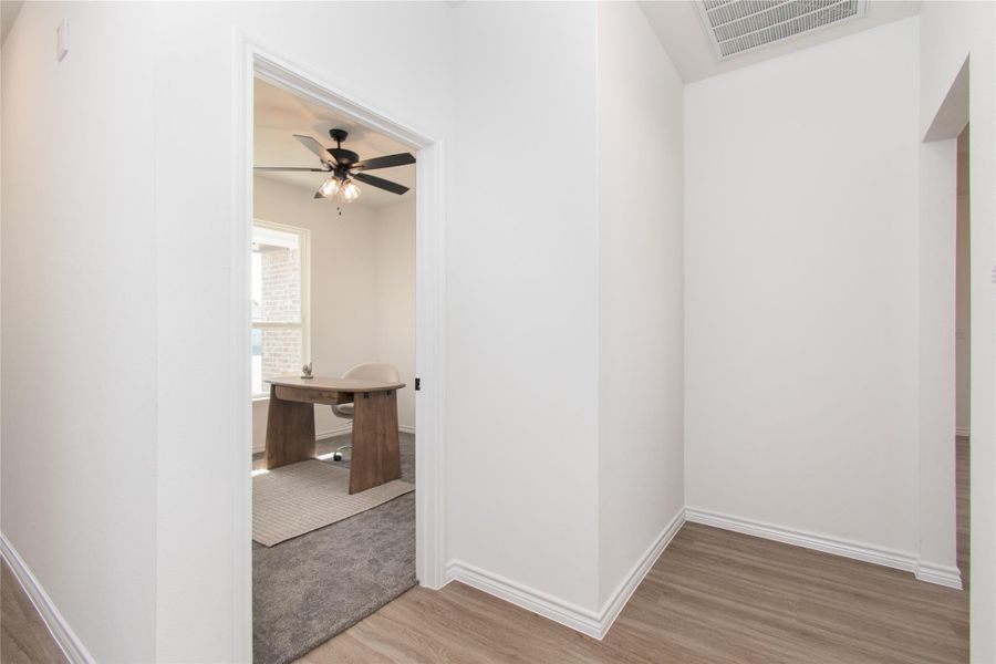 Hallway with light wood-style flooring and an office area