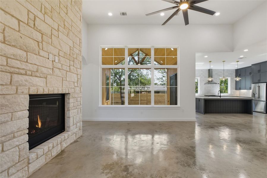 living room with plenty of natural light, concrete floors, a fireplace, recessed lighting, and ceiling fan living room with plenty of natural light, concrete floors, a fireplace, recessed lighting, and ceiling fan