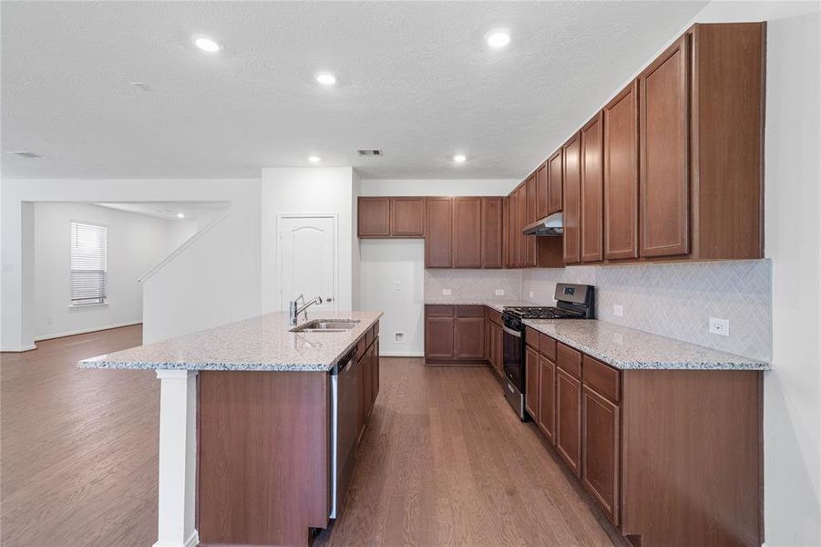 This kitchen is by far any chef’s dream! This spacious kitchen features high ceilings, stained cabinets, granite countertops, SS appliances, modern tile backsplash, recessed lighting, large kitchen island with extended countertop for breakfast bar, and a walk-in pantry all overlooking your huge family room.