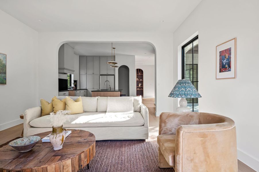 An inviting open-concept living space features light wood flooring and a seamless transition to the kitchen.
