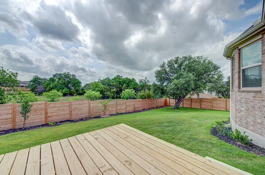 A spacious lawn and a new wooden deck overlook the fenced backyard. A spacious lawn and a new wooden deck overlook the fenced backyard.