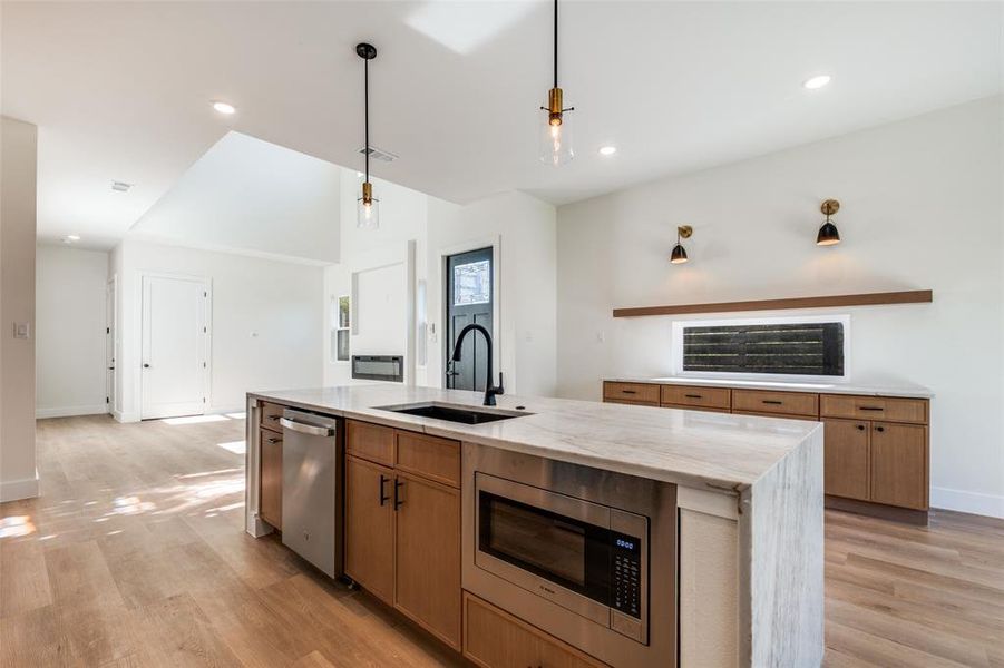Kitchen featuring stainless steel appliances, light stone counters, light wood-type flooring, and recessed lighting