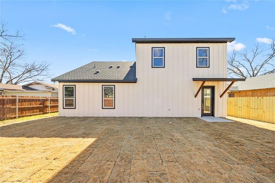 Back of house featuring a fenced backyard, board and batten siding, and roof with shingles Back of house featuring a fenced backyard, board and batten siding, and roof with shingles