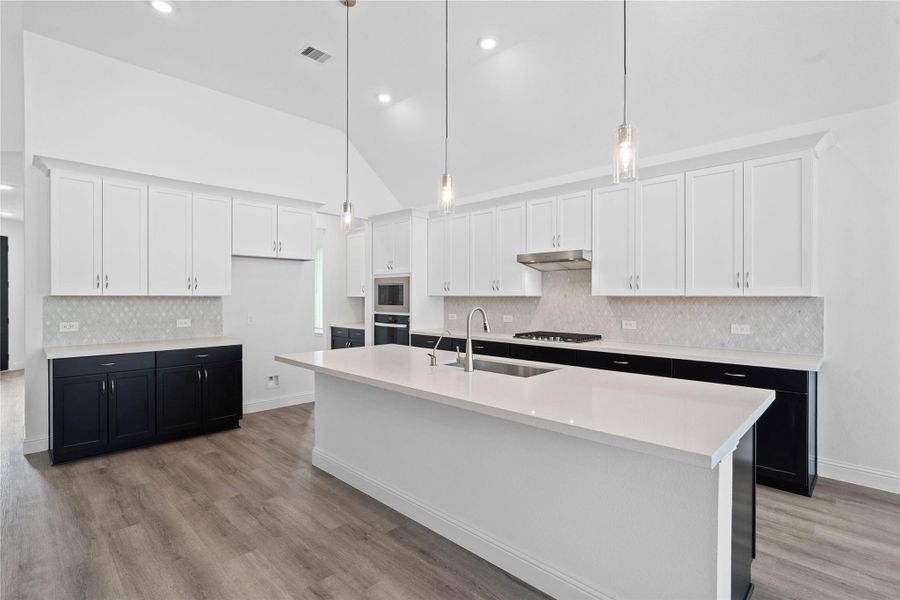 Pristine and functional, the central kitchen island provides both a focal point and practical prep space in this modern gourmet kitchen. Pristine and functional, the central kitchen island provides both a focal point and practical prep space in this modern gourmet kitchen.