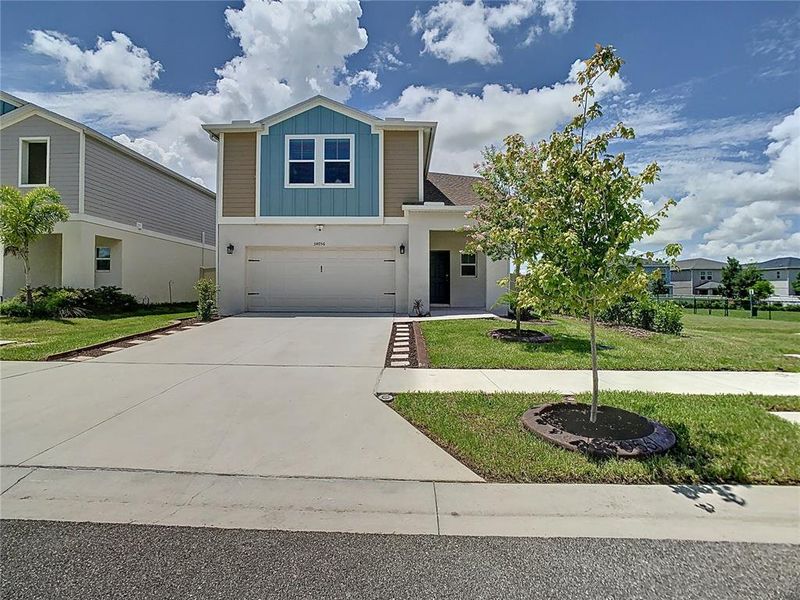 Front exterior of a new home in Pasadena Point, Wesley Chapel, FL, highlighting curb appeal (Image 25). Front exterior of a new home in Pasadena Point, Wesley Chapel, FL, highlighting curb appeal (Image 25).
