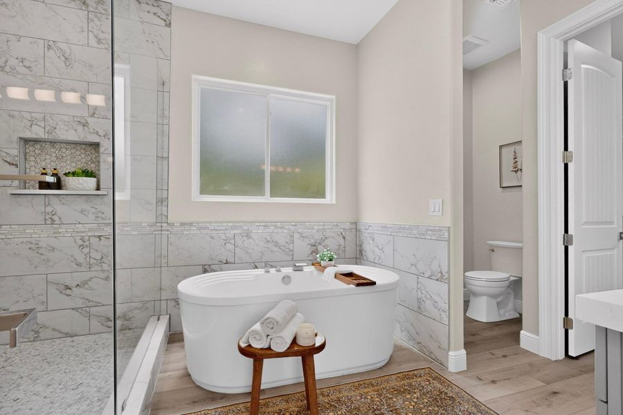 A freestanding tub and walk-in tiled shower anchor this serene space.