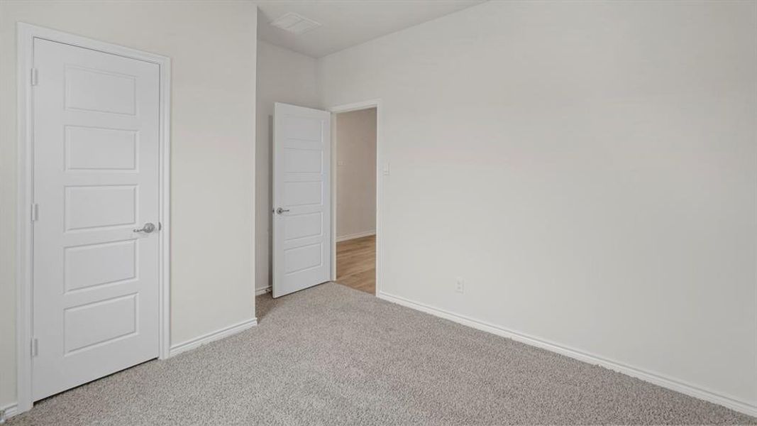 Unfurnished bedroom featuring light colored carpet and baseboards Unfurnished bedroom featuring light colored carpet and baseboards