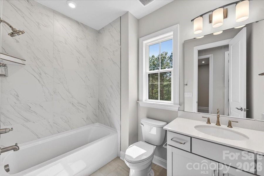 Secondary bathroom with tiled walls above the tub Secondary bathroom with tiled walls above the tub