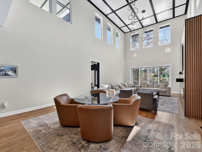 Bright, open-concept family room with soaring ceilings, a statement fireplace wall, and seamless flow into the kitchen and dining areas.