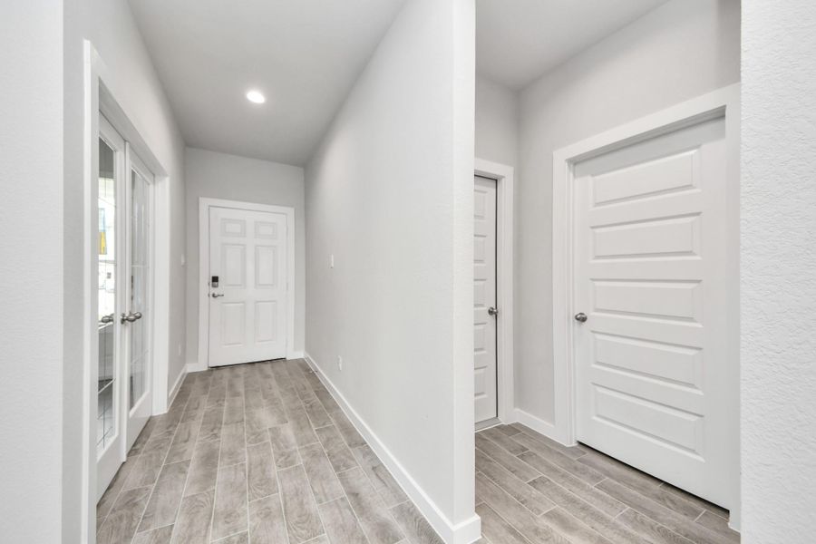 As you step into the threshold of this luxurious home, you'll soon be welcomed by an elegant glass door (to be installed). Inside, soaring ceilings amplify the spaciousness, while the refined wood-look tile flooring and oversized baseboards exude sophistication and charm. Sample photo of completed home with similar floor plan. Actual colors and selections may vary.