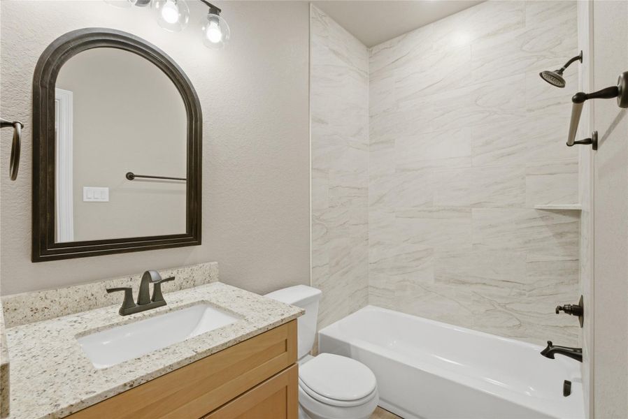Full bathroom with vanity, shower / washtub combination, and a textured wall