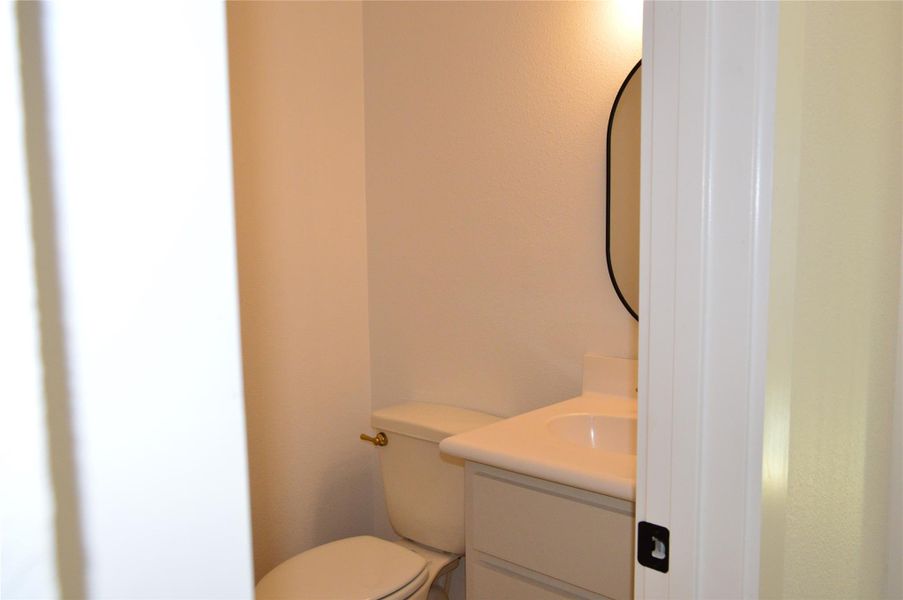 Half bathroom featuring vanity and toilet Half bathroom featuring vanity and toilet