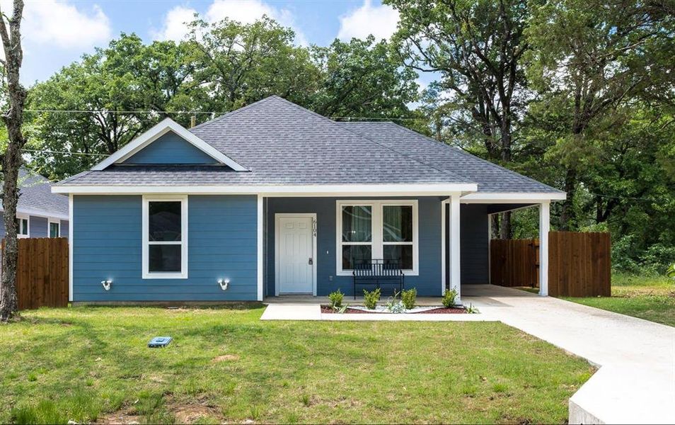 View of front of house featuring a front yard, a porch, and a carport